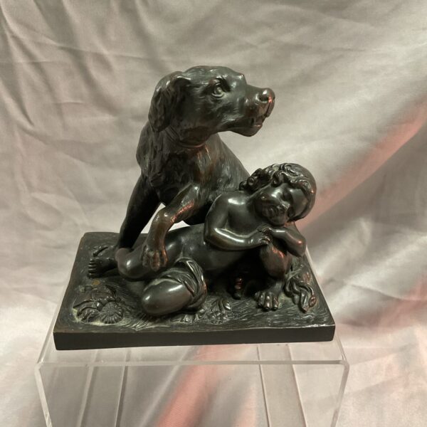 Front view of a bronze dog and child sculpture.