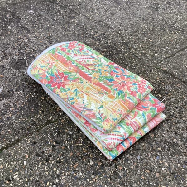 Three vintage floral sun lounger cushions for garden seating.