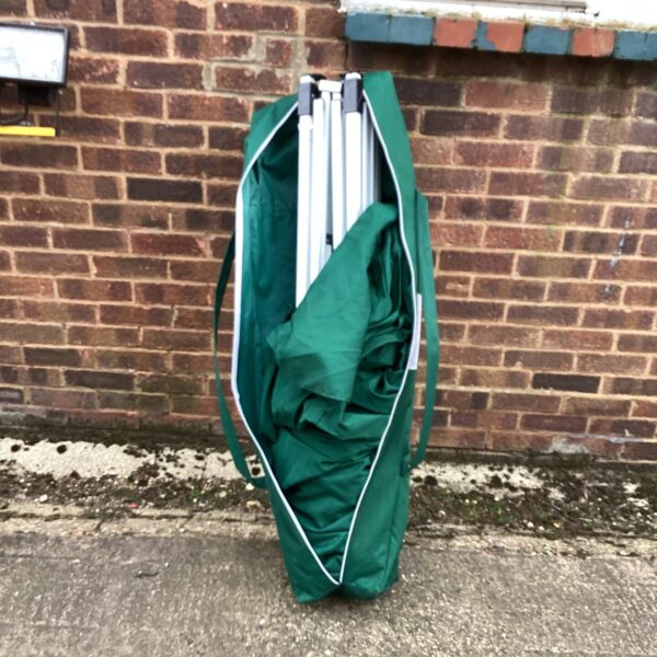 Collapsed telescopic gazebo in a green carry bag.