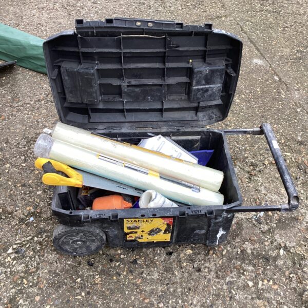Closed Stanley tool box with various tools and hardware inside.