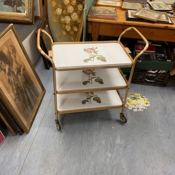 Vintage three-tier butler trolley with wooden frame and laminate tiers.