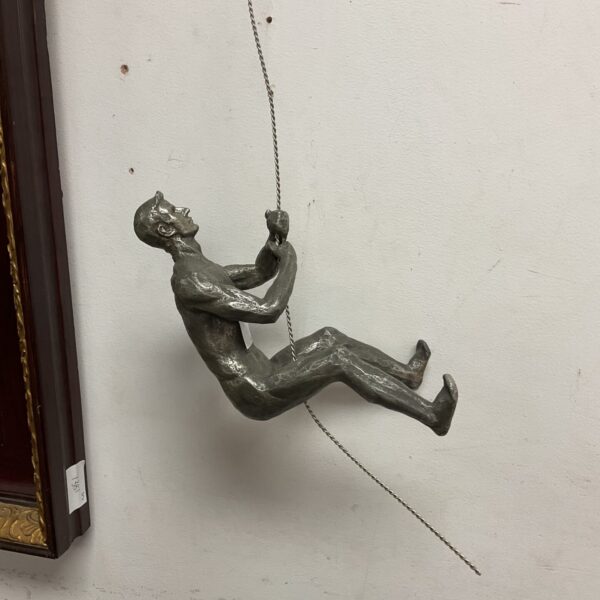 Vintage metal rock climbing sculpture for wall display.