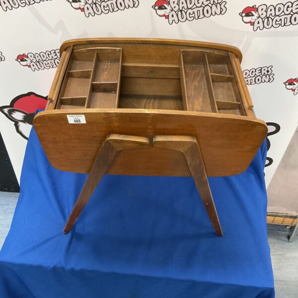 Vintage wooden roll top sewing box with open compartments.