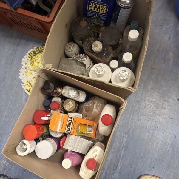 Assorted shed clearance chemicals and fluids in a cardboard box.