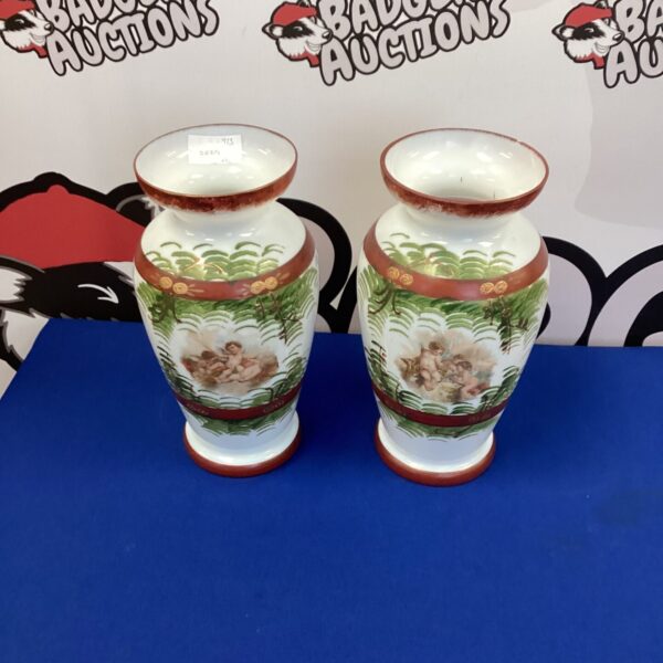 Antique milk glass vases with hand-painted cherubs and floral designs.