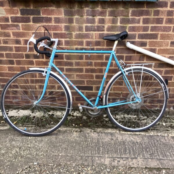 Vintage Peugeot racing bike in a garden setting.