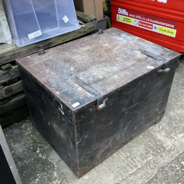 Large metal storage container with a hinged lid, showing signs of wear.