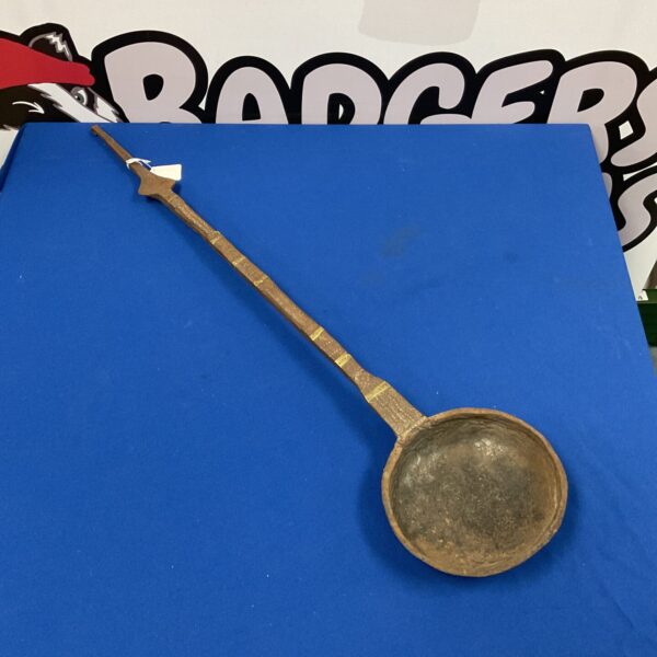 Antique iron ladle with a deep bowl and rustic patina.