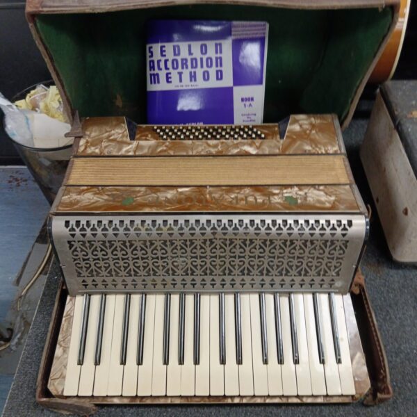 Front view of vintage Puratone accordion for restoration.