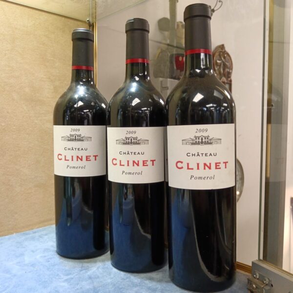 Three bottles of Chateau Clinet Pomerol 2009 vintage red wine.