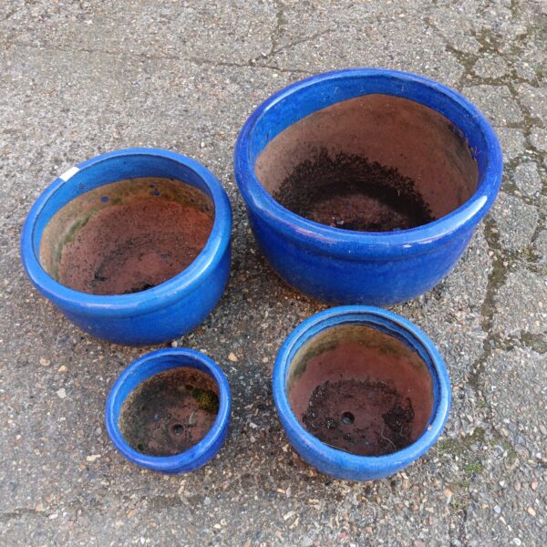 Set of four vibrant blue glaze garden planters for outdoor use.