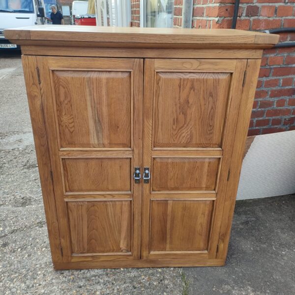 Large solid oak unit with internal shelving for home storage.