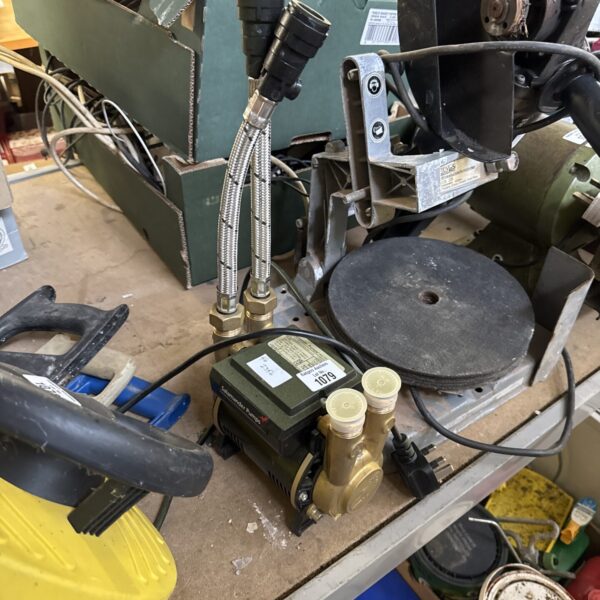 Front view of a used Salamander shower pump with connections.