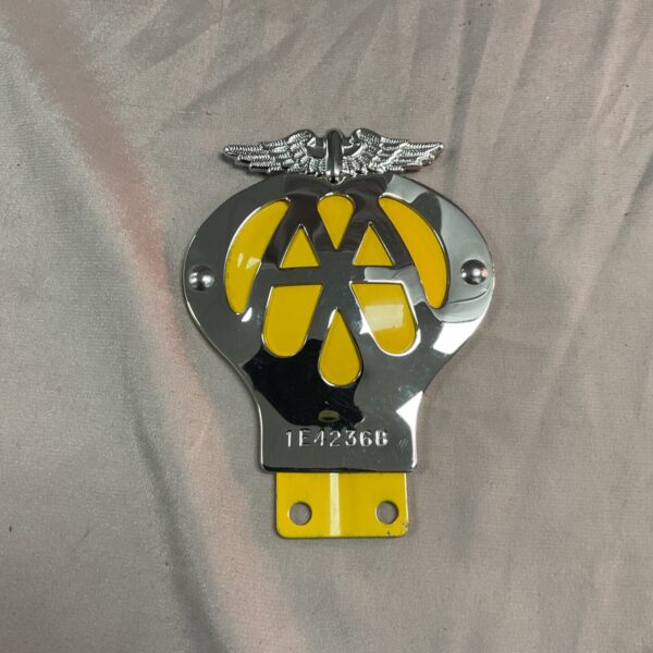 Vintage AA car badge with yellow and black emblem.