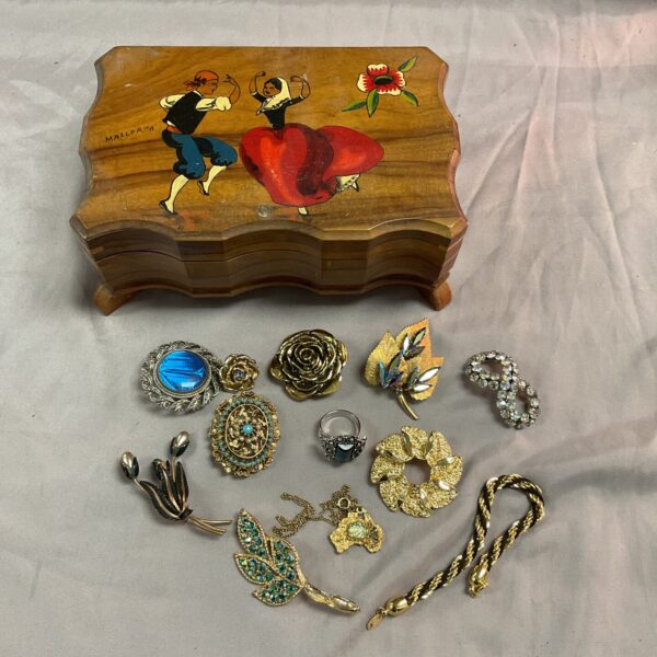 Vintage musical jewellery box with assorted costume jewellery inside.