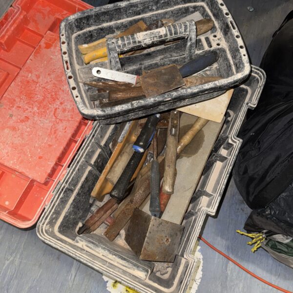 Vintage metal toolbox filled with a collection of antique hand tools.