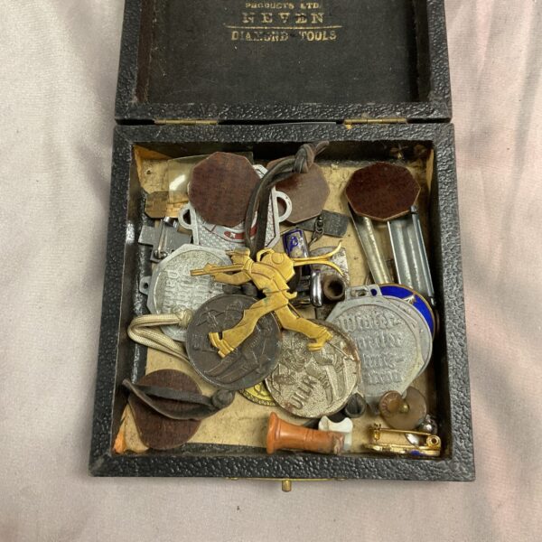 Vintage box filled with a collection of antique trinkets and small collectibles.