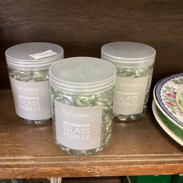 Three clear jars filled with decorative glass pebbles for home decor.