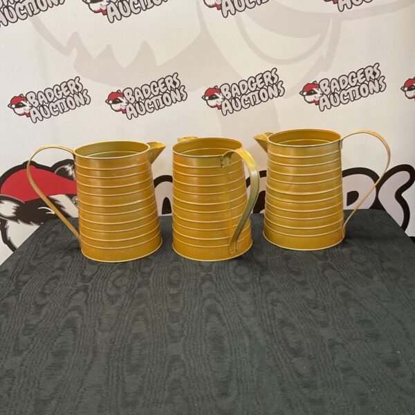 Three large vintage tin jugs for flower display.