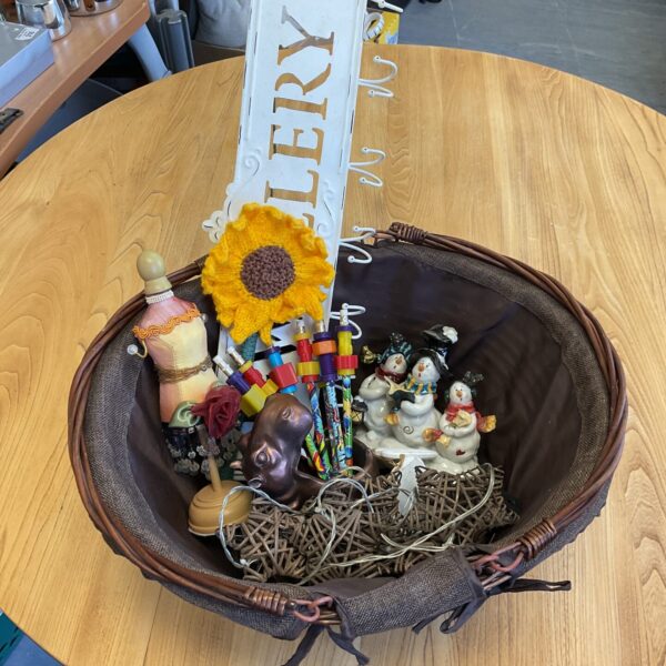 Woven basket filled with a mixed lot of vintage and modern collectibles.