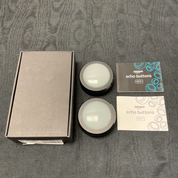 Pair of Amazon Echo Buttons for smart home interaction.