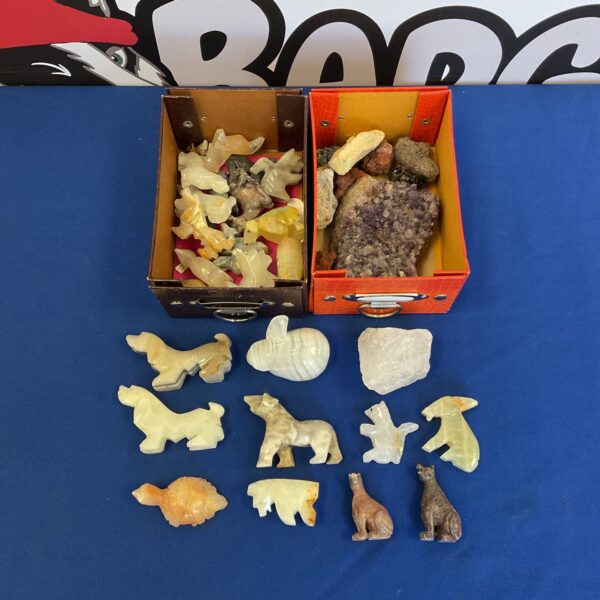 Close-up of carved stone animal and crystal collection.