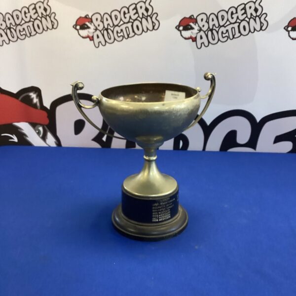Vintage silverplate sports trophy with ornate handles and base.