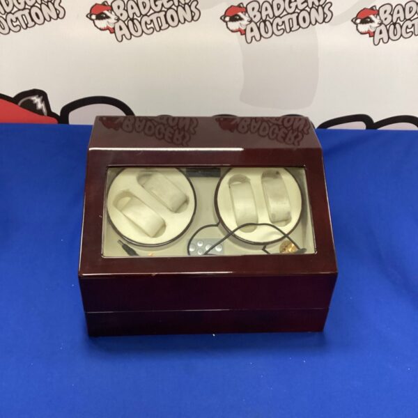 Polished wood automatic watch winder for timepiece maintenance.