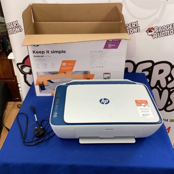 HP Deskjet 2721e wireless printer on a blue surface.