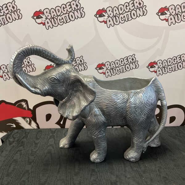 Large metal elephant planter in a garden setting.