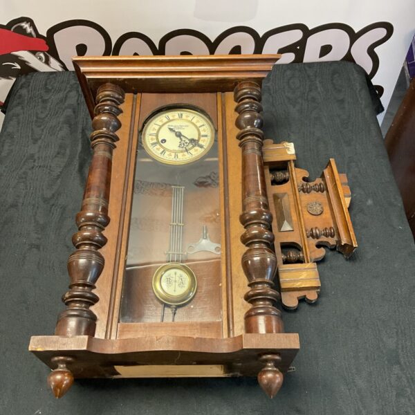 Antique Fattorini & Sons wall clock with brass face and wooden case.