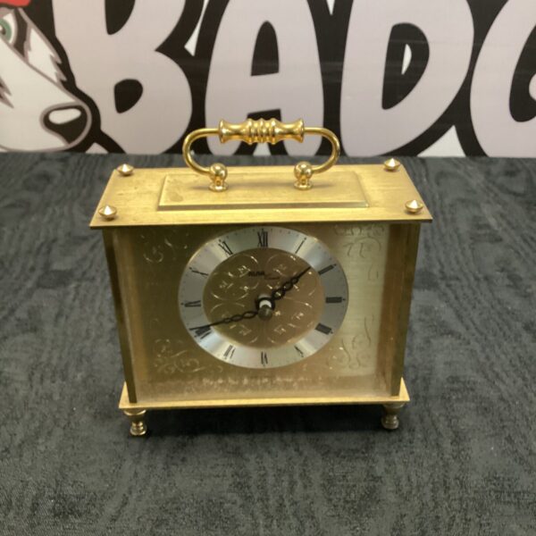 Vintage brass Avia mantle clock on a surface.