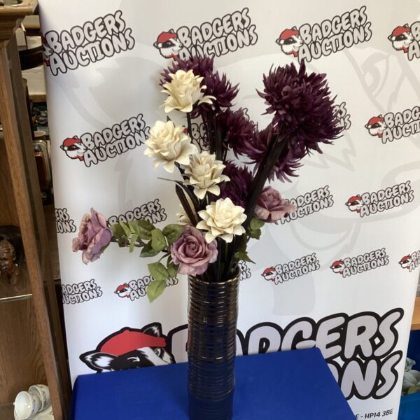 Tall vase with vibrant artificial flower arrangement for home decor.