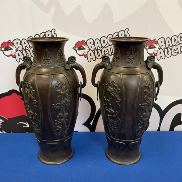 Antique Japanese bronze vases with bird patterns, detailed craftsmanship.