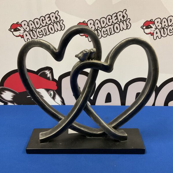 Close-up of entwined hearts resin sculpture with birds.