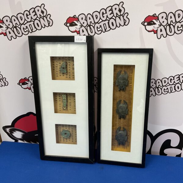 Framed collection of vintage Chinese metal masks and tokens.