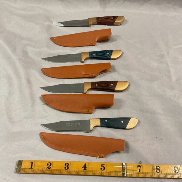 Lot of four small sheath knives with leather sheaths.