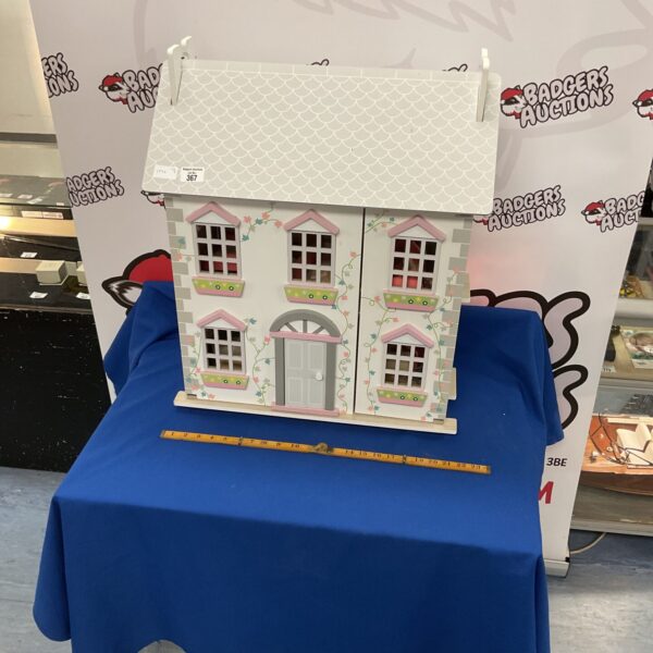 Pastel pink and cream wooden dolls house with furniture.