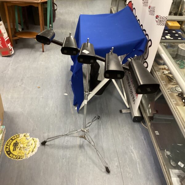 Vintage cowbell set with adjustable stand for musical performance.