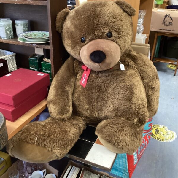 Large vintage Hambleys teddy bear on display.