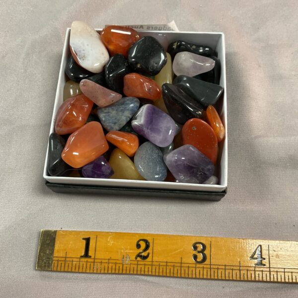 Polished semi-precious stones in a display box, gemstone collection.