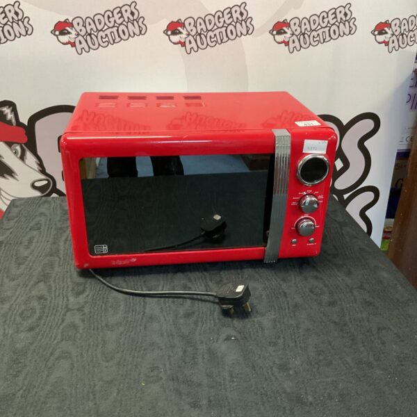 Front view of a red Swan microwave in used condition.