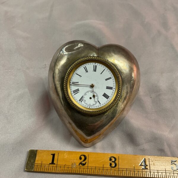 Antique silver heart-shaped travel clock with Roman numerals.