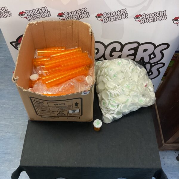 Wholesale lot of new pill pots and lids in a cardboard box.