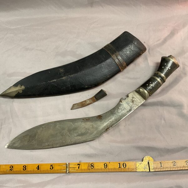 Vintage Indian Kukri knife with decorated scabbard and etched blade.