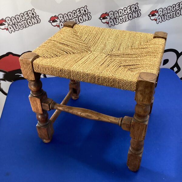 Vintage woven top stool with turned legs, rustic farmhouse style.
