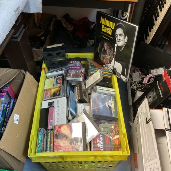 Crate filled with a large collection of music CDs and cassette tapes.