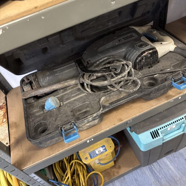 Side view of a used Mac Allister concrete breaker.