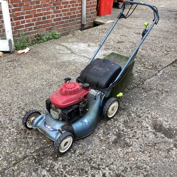 Front view of a Honda petrol lawn mower in a garden.