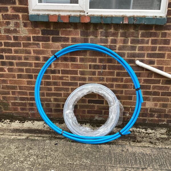 Two rolls of plastic water pipe for garden or plumbing use.